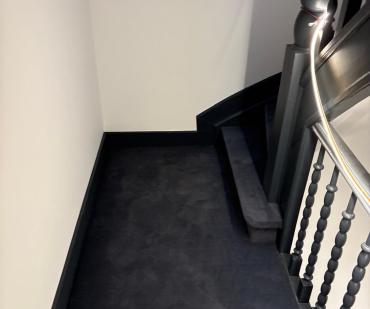 Cage d'escalier rénovée avec un tapis anthracite